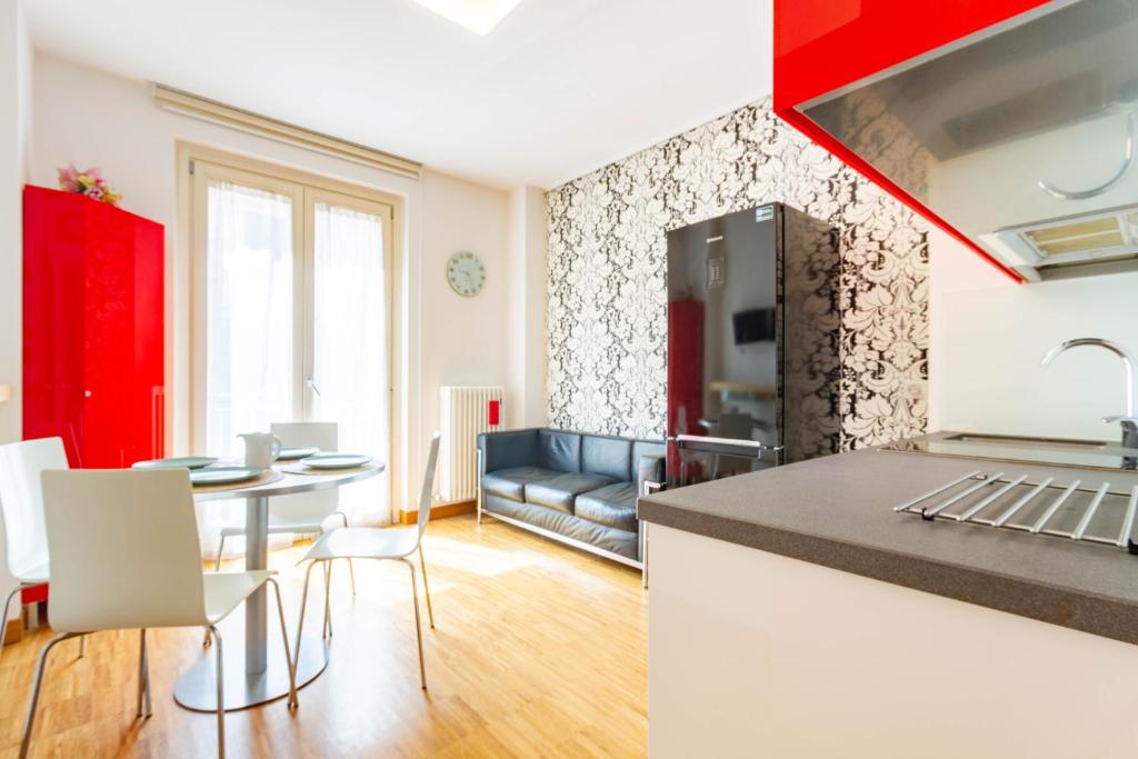 eine Küche und ein Wohnzimmer mit einem Tisch und Stühlen in der Unterkunft Appartamento Duplex Cairoli - MyHo Casa in Porto San Giorgio