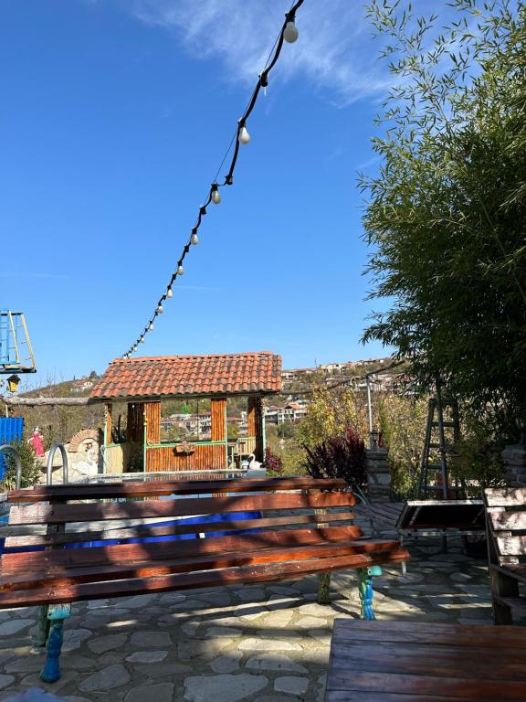 a wooden bench in front of a building at Guest House Iura in Sighnaghi