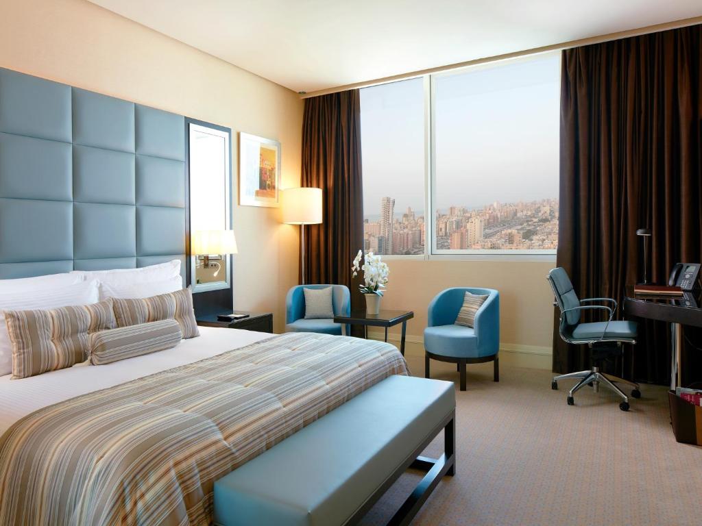 Millennium Hotel & Convention Centre Kuwait tesisinde bir odada yatak veya yataklar
