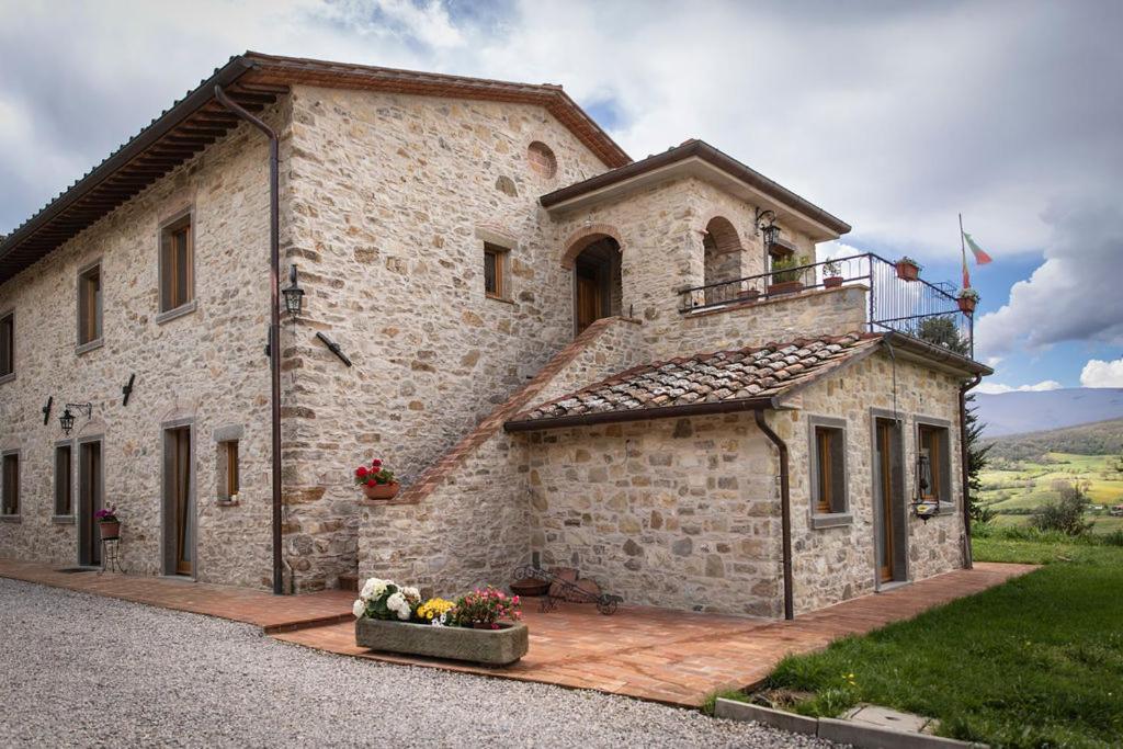 een stenen gebouw met een balkon aan de zijkant bij Agriturismo Le Pozze in Poppi