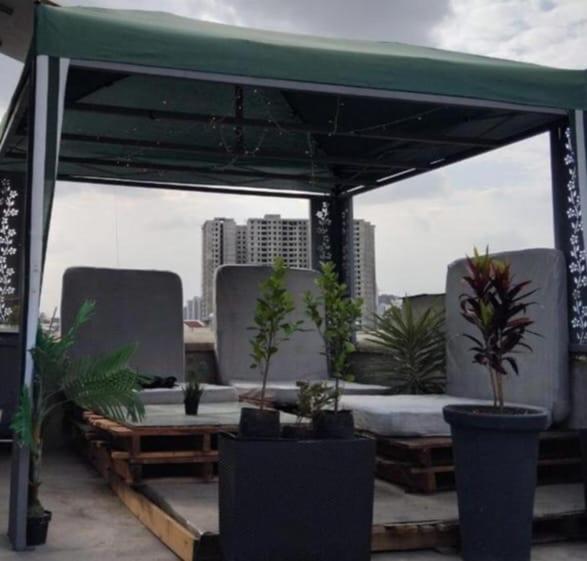 a pergola with chairs and potted plants on a rooftop at Gemütliches Zimmer in guter Lage in Addis Ababa