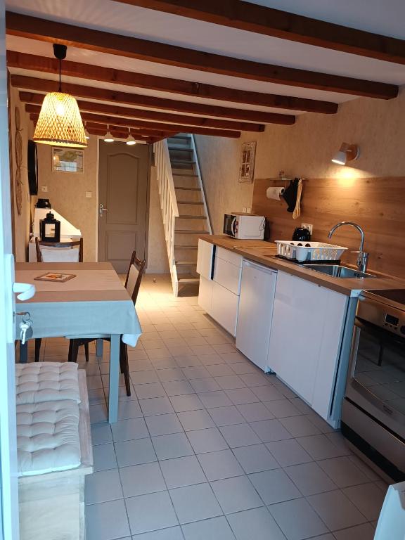 une cuisine avec une table et un comptoir dans l'établissement Gîte coeur de Brocéliande, à Néant-sur-Yvel