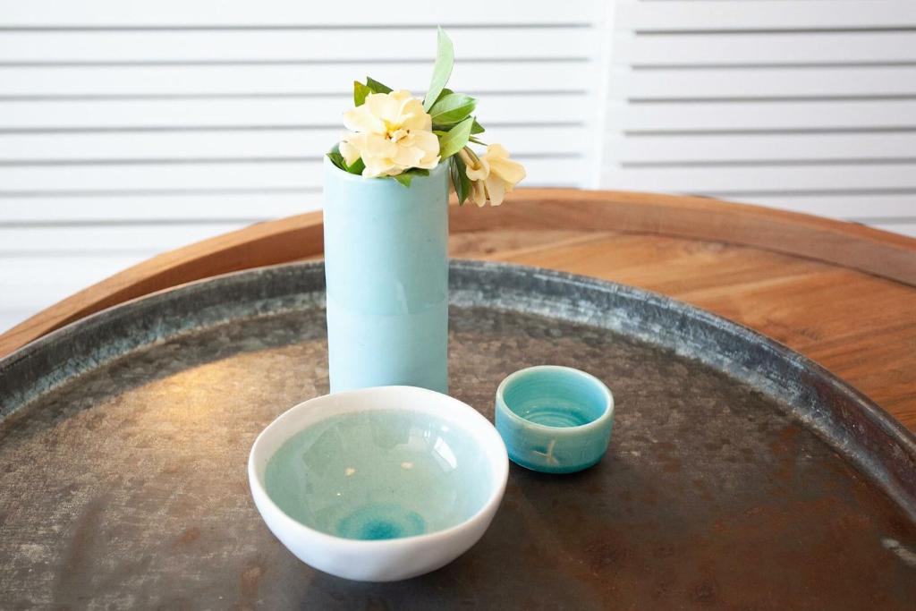 a vase with flowers in it sitting on a table at Barefoot in Bronte IH in Sydney