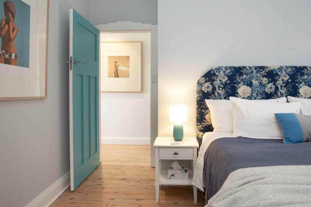 a bedroom with a bed and a lamp on a table at Barefoot in Bronte IH in Sydney