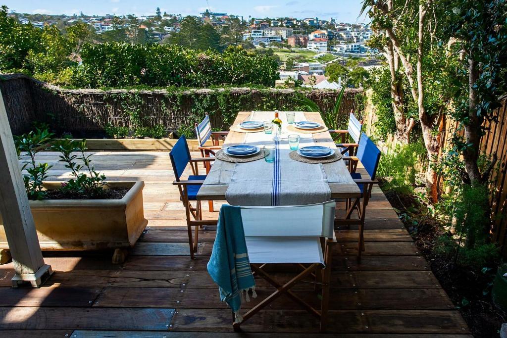 a long table with blue plates and chairs on a patio at Barefoot in Bronte IH in Sydney