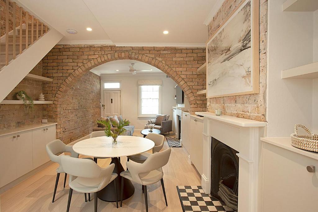 a kitchen with a table and chairs and a fireplace at Wharf House Woolloomooloo in Sydney