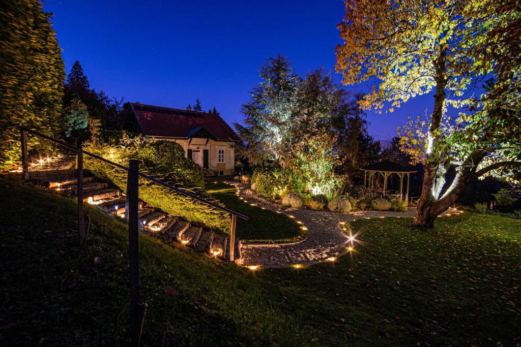 uma casa com luzes no quintal à noite em Villa Mimi em Sopron