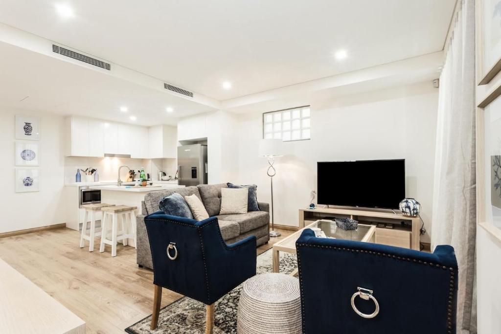 uma sala de estar com um sofá e uma televisão em Charming Bream em Sydney
