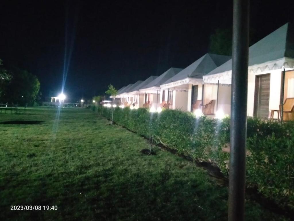 a row of houses in a field at night at Vacation Village Camps - A Unit Of Braham Vatika Resort in Pushkar