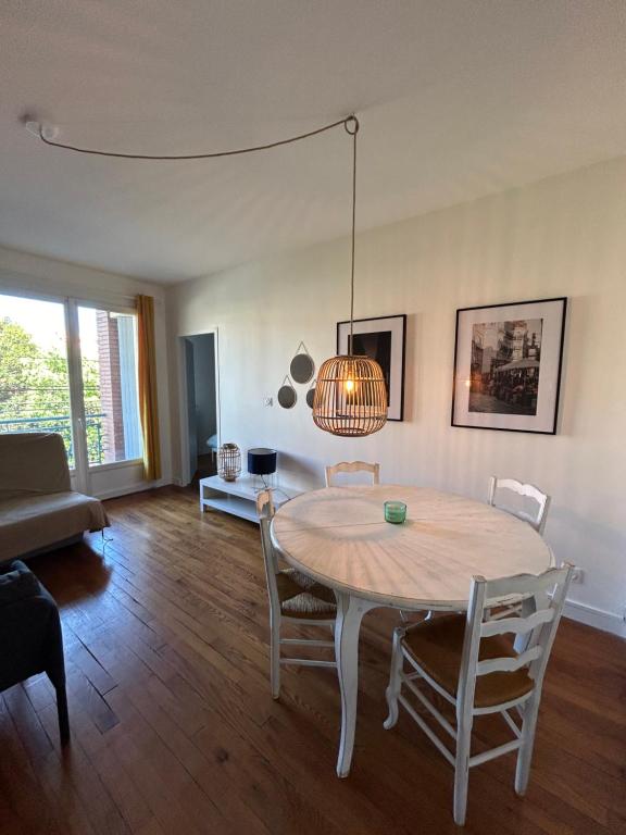 un salon avec une table, des chaises et un canapé dans l'établissement Le Louis Vitet terrasse proche place Dupuy, à Toulouse