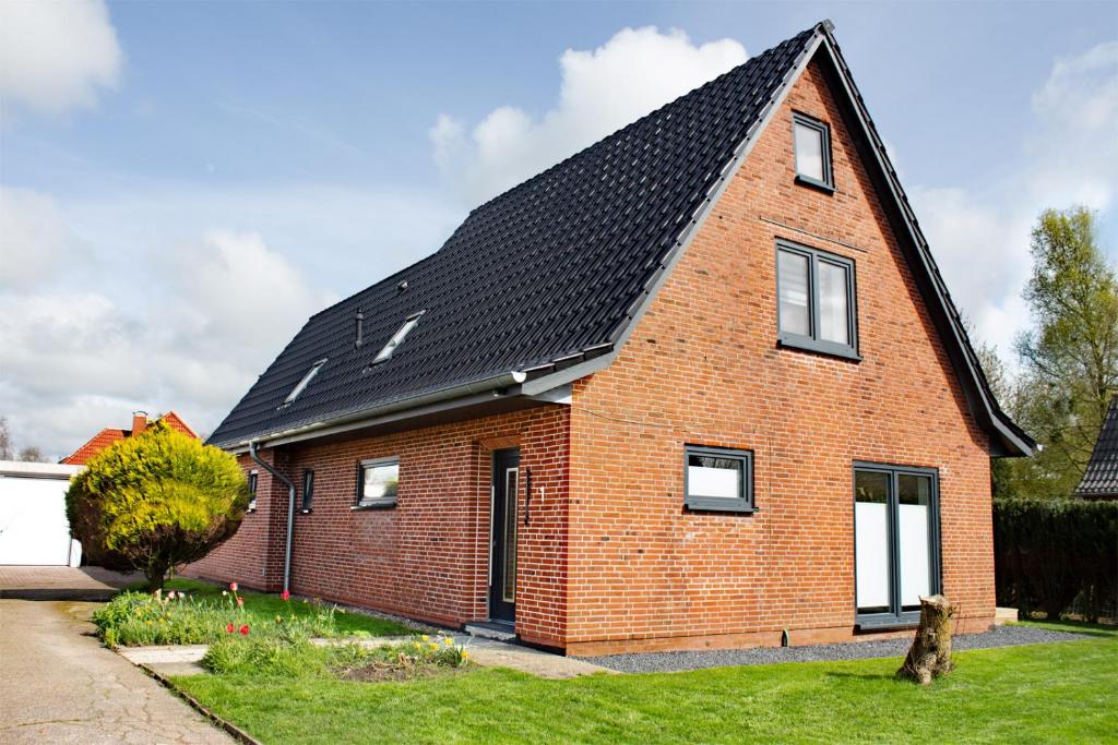 a red brick house with a black roof at Ferienwohnung Emilia in Garding