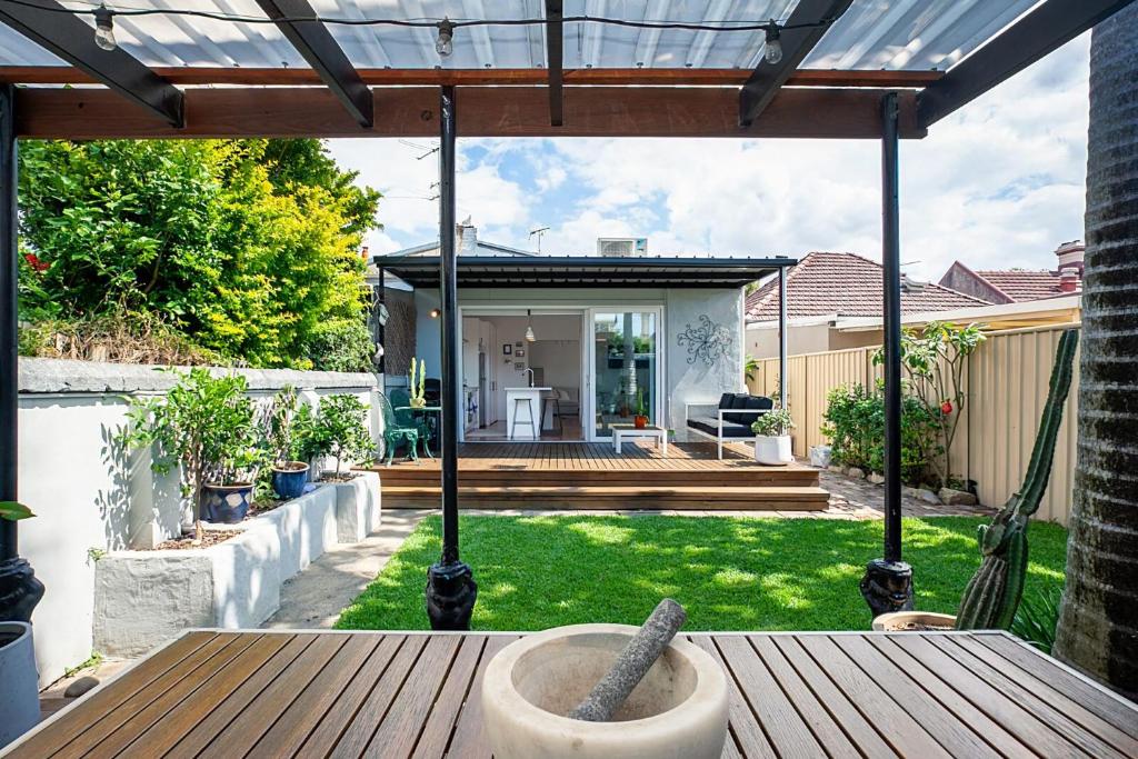 a patio with a wooden table in a yard at Garden Oasis Sydenham in Sydney