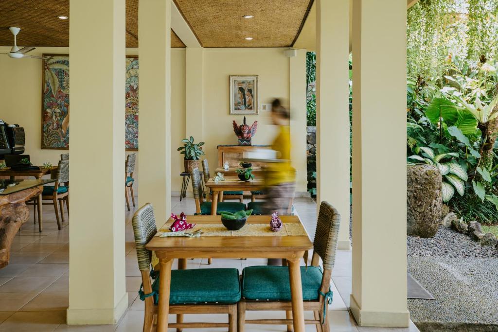a dining room with a table and chairs at Jati Cottage in Ubud