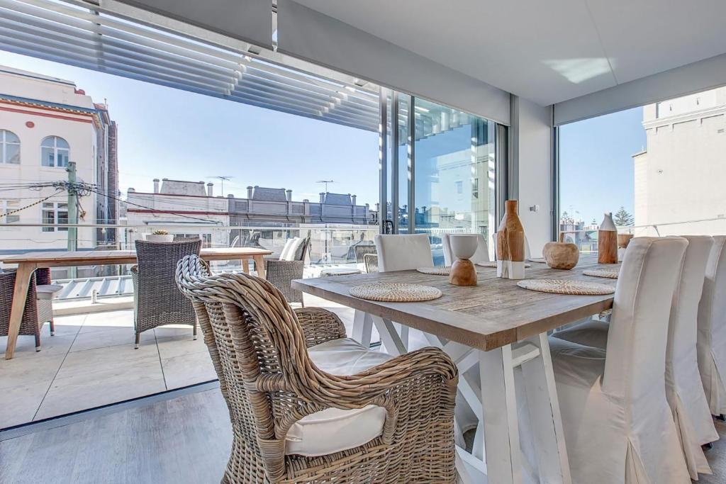 jadalnia ze stołem i krzesłami w obiekcie Coogee Bay Penthouse w mieście Sydney