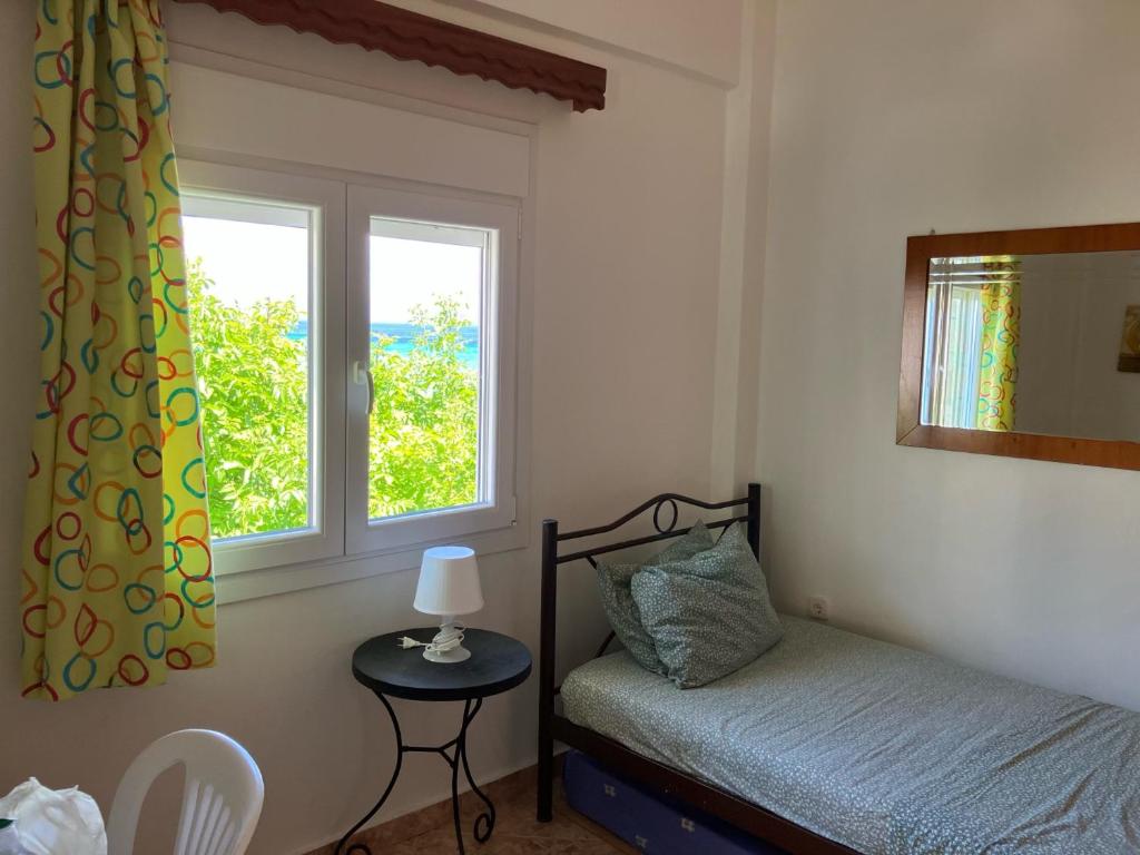 Habitación pequeña con cama y ventana en The Family Place - Cosy Double bedroom apartment on beach of Kallithea, Chalkidiki, en Kallithea Halkidikis