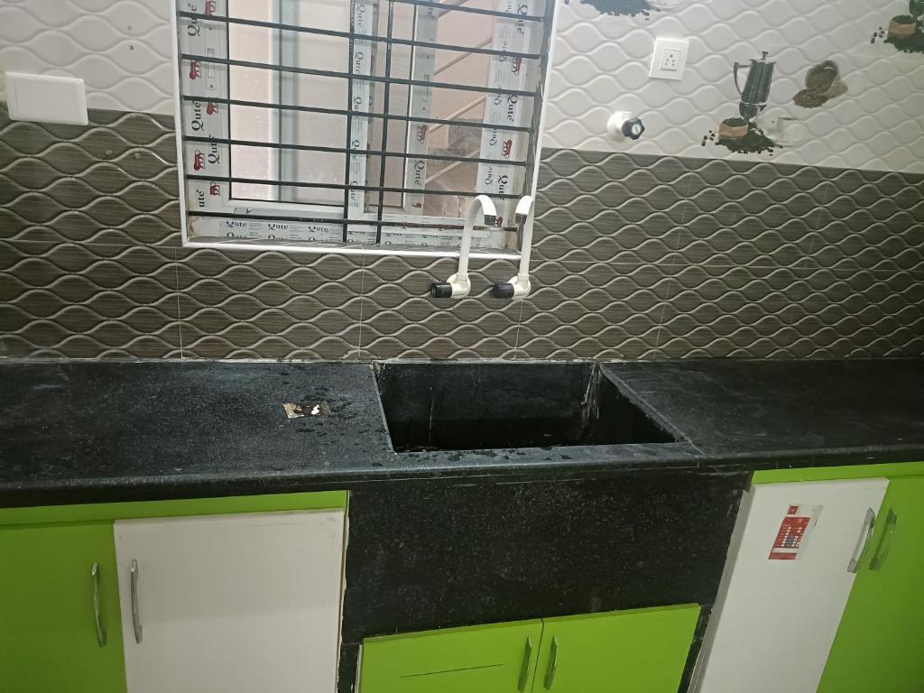 um balcão de cozinha com um lavatório na cozinha em SREENIVASA HOME STAY em Tirupati