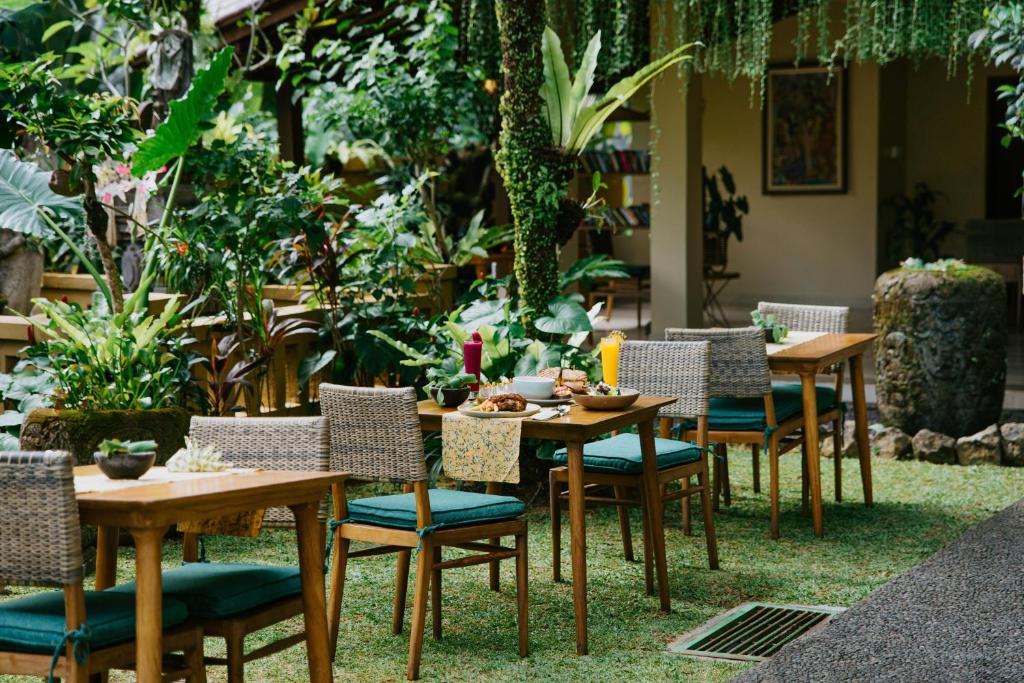 a group of tables and chairs in a garden at Jati Cottage in Ubud