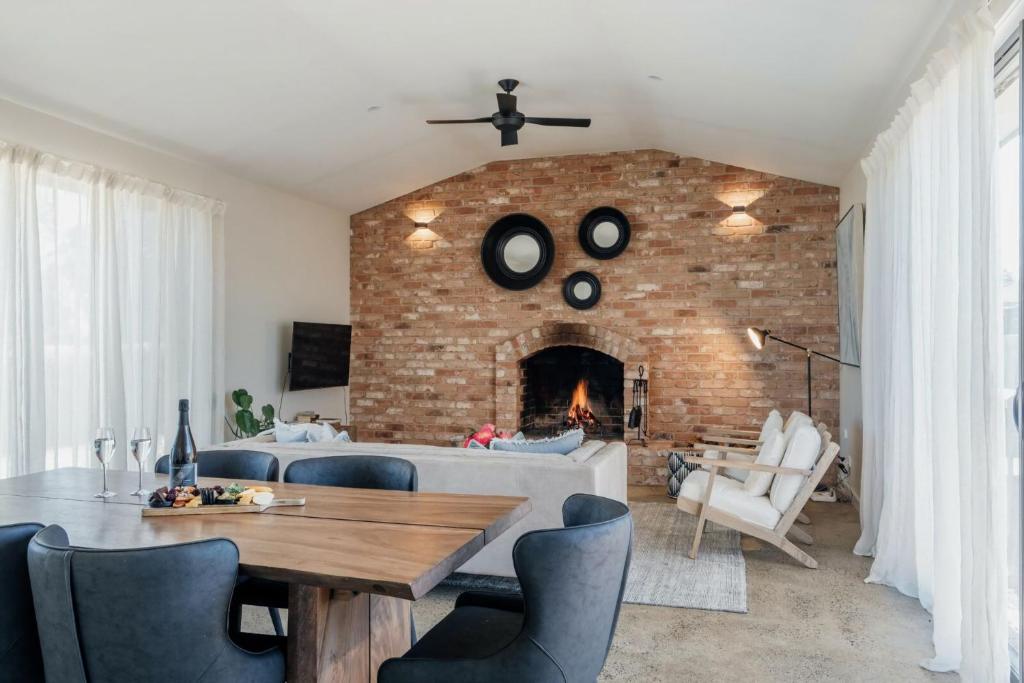 a living room with a brick wall and a fireplace at Embracing Evandale in Evandale
