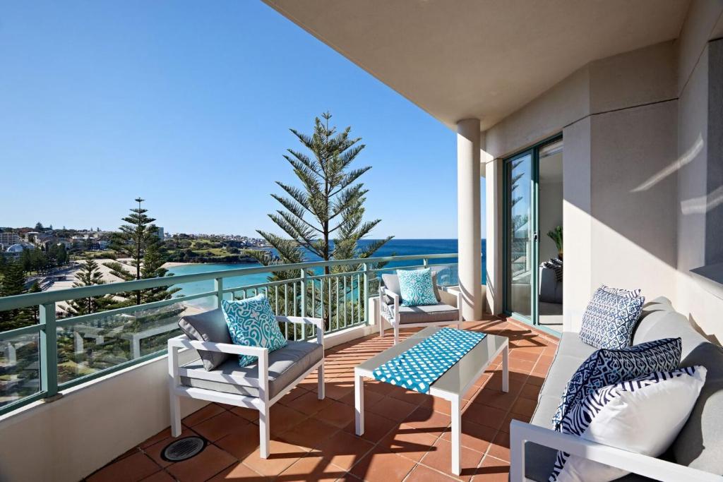 a balcony with chairs and a view of the ocean at Palm Breeze in Coogee in Sydney