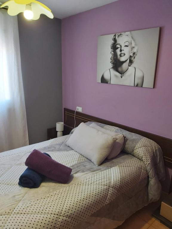 デルテブレにあるApartamento Mandalaの紫の壁のベッドルーム1室、ベッド1台(枕付)