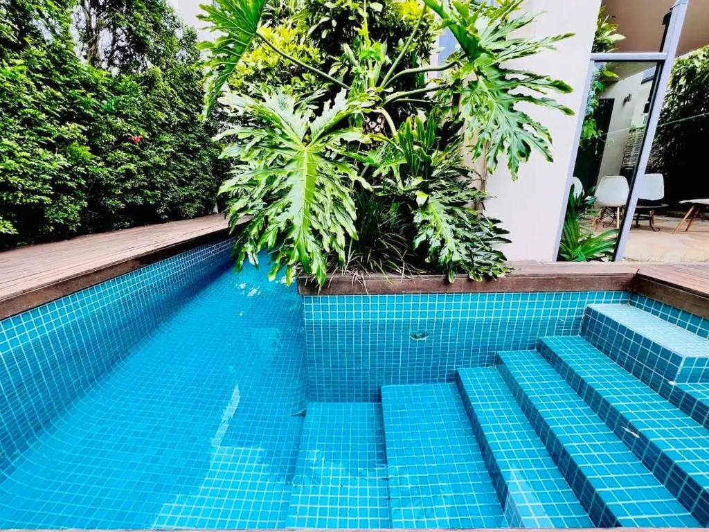 a swimming pool with blue tiles in front of a house at Picture-Perfect Masterpiece In Mosman in Sydney