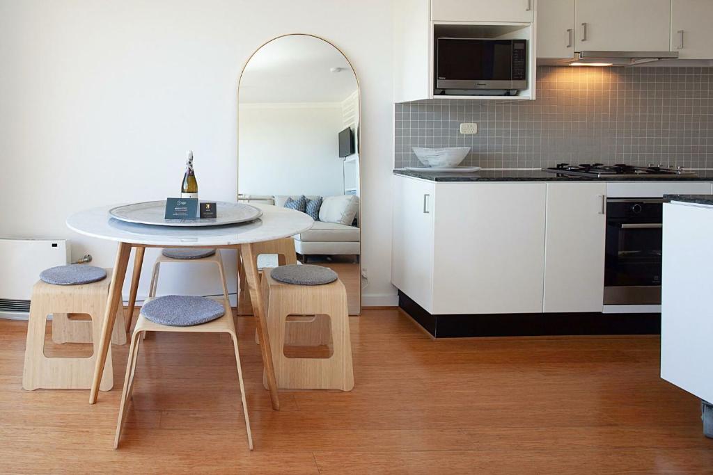 a kitchen with a table and chairs in a room at Ocean view Clovelly in Sydney