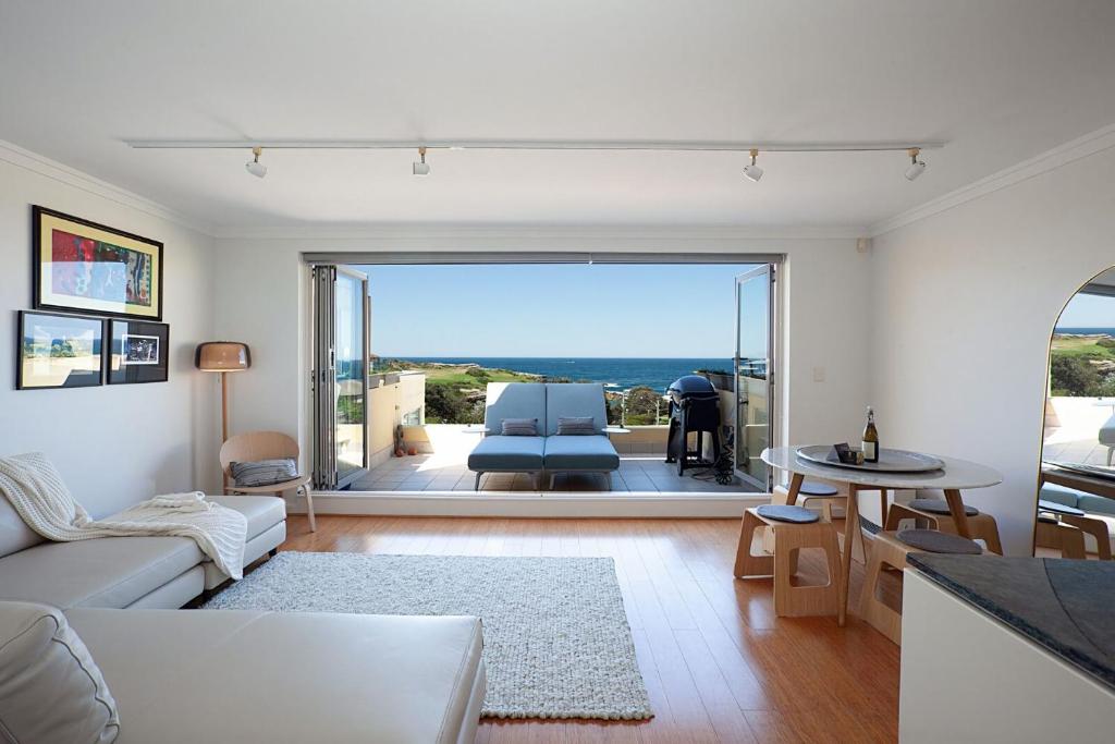 uma sala de estar com um sofá e uma mesa em Ocean view Clovelly em Sydney