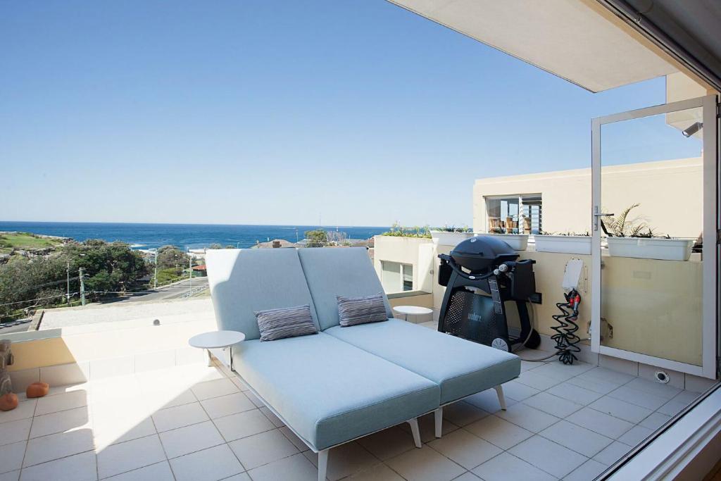 a blue chair sitting on top of a balcony at Ocean view Clovelly in Sydney