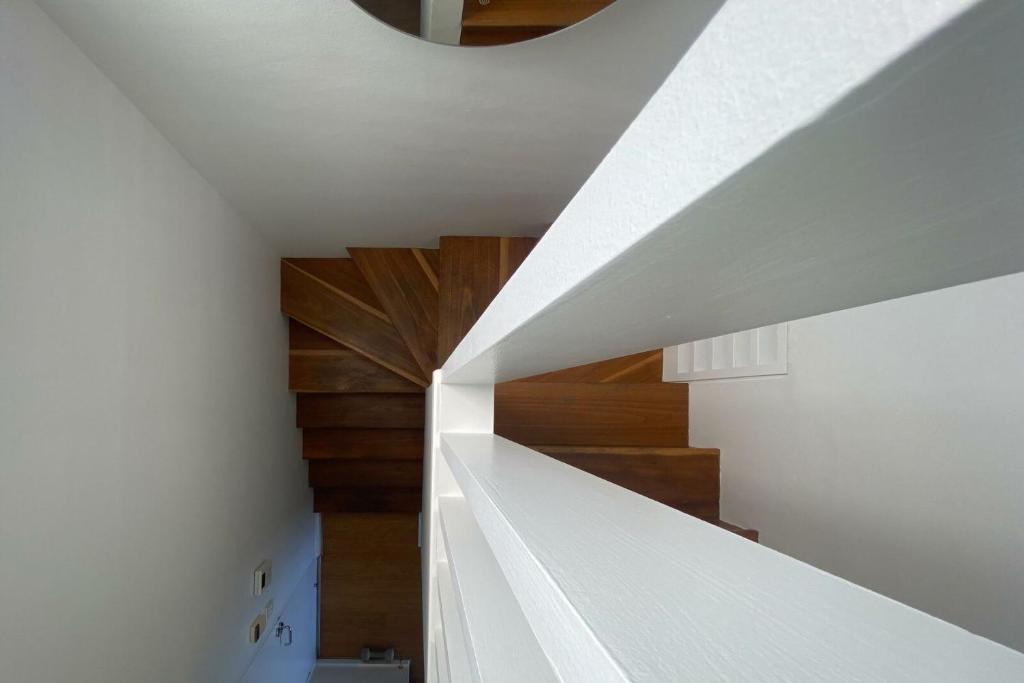 a white staircase in a house with wooden floors at Ocean view Clovelly in Sydney