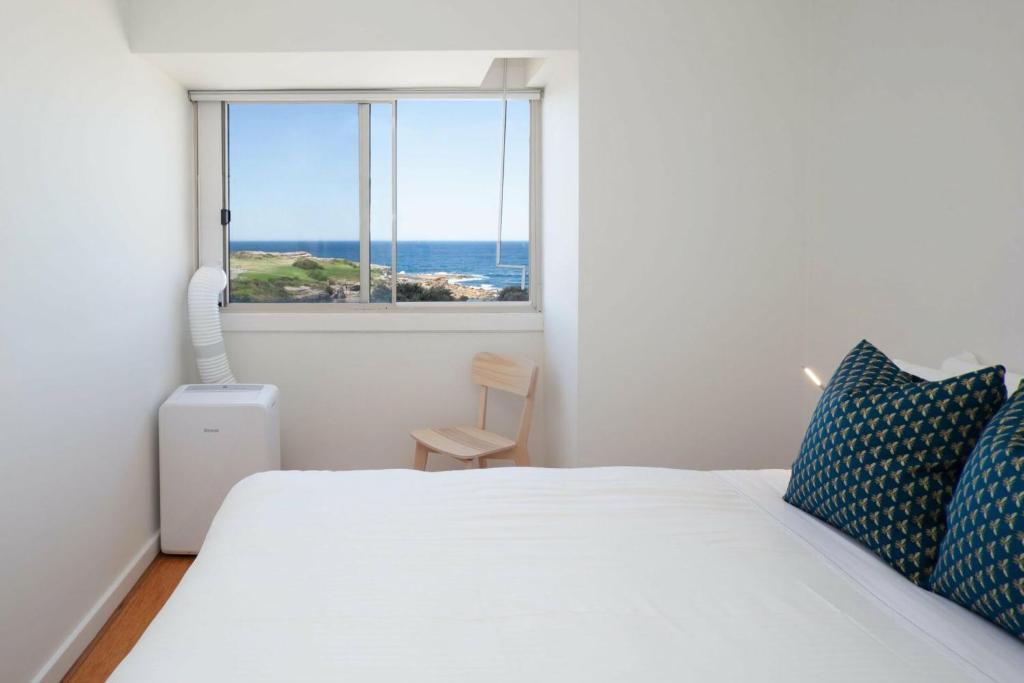a bedroom with a bed with a view of the ocean at Ocean view Clovelly in Sydney