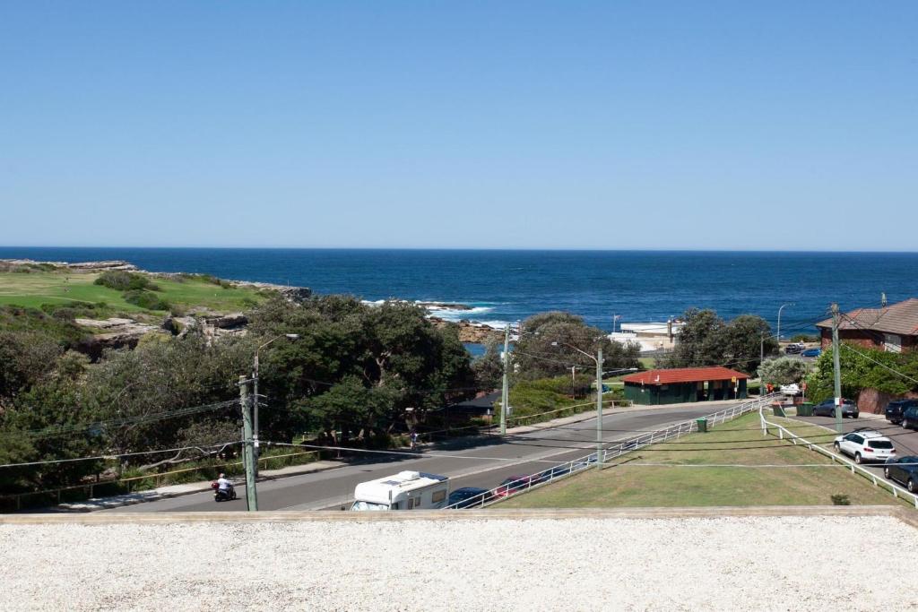 a view of a road with the ocean in the background at Ocean view Clovelly in Sydney