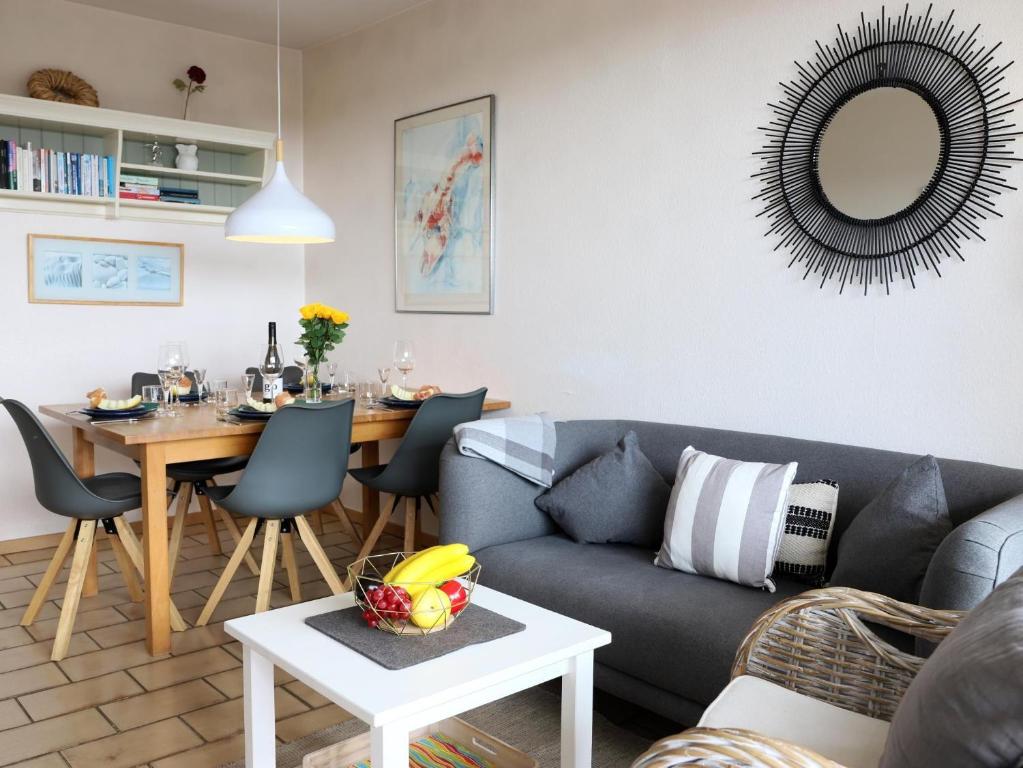 uma sala de estar com um sofá e uma mesa em Fernsicht-12b-EG em Wenningstedt