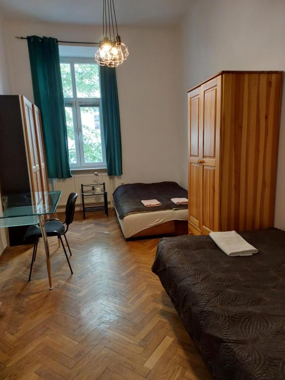 a room with a bed and a table and a window at Apartment Mariacki Tower in Krakow