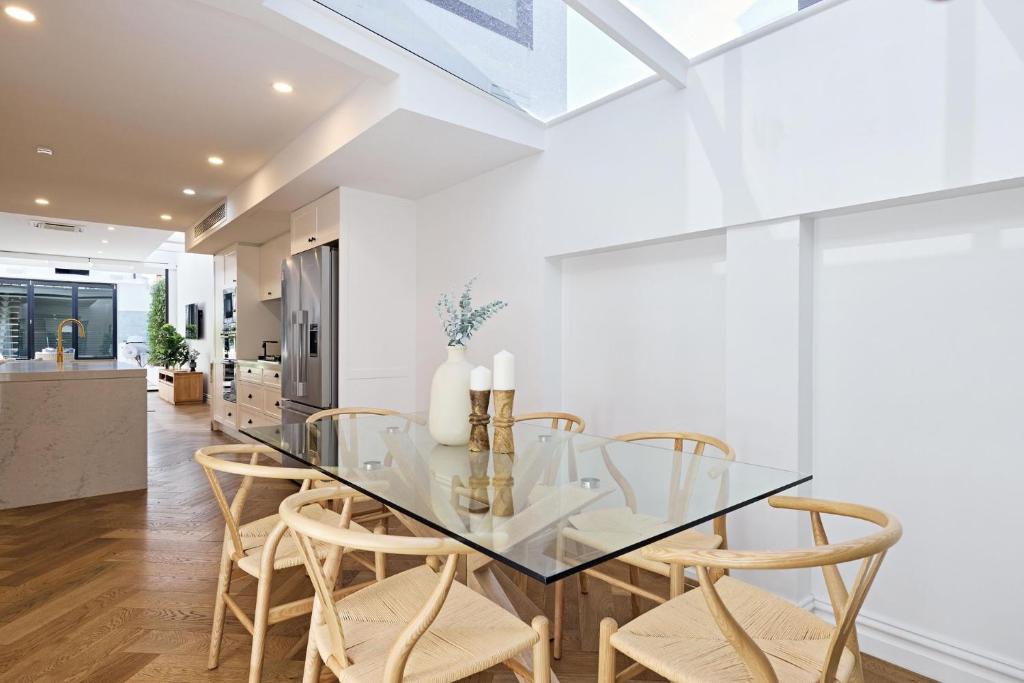 a dining room with a glass table and chairs at Royal Redfern Isyd in Sydney