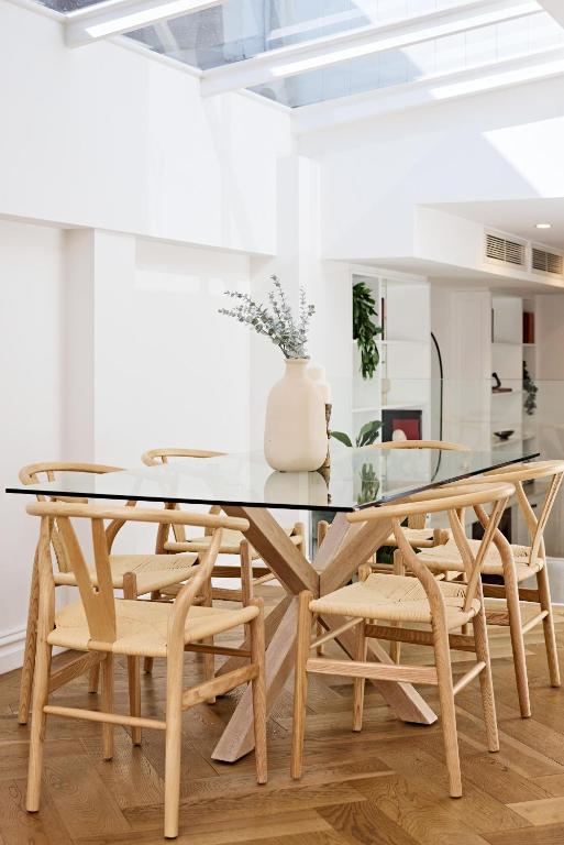 a dining room with a glass table and chairs at Royal Redfern Isyd in Sydney