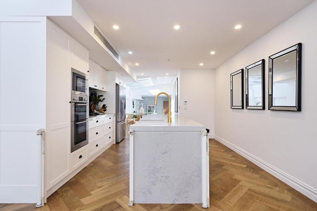a kitchen with white walls and a white counter top at Royal Redfern Isyd in Sydney
