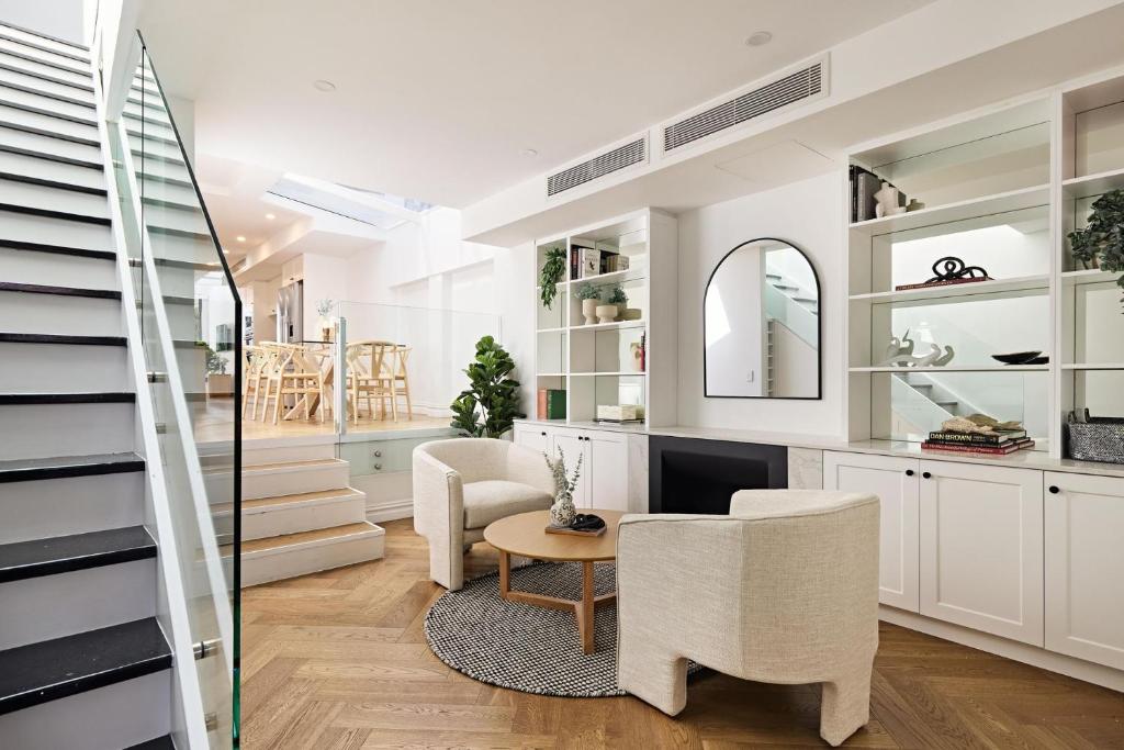 a living room with a staircase and a table and chairs at Royal Redfern Isyd in Sydney