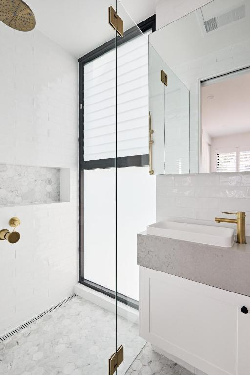 a white bathroom with a sink and a window at Royal Redfern Isyd in Sydney