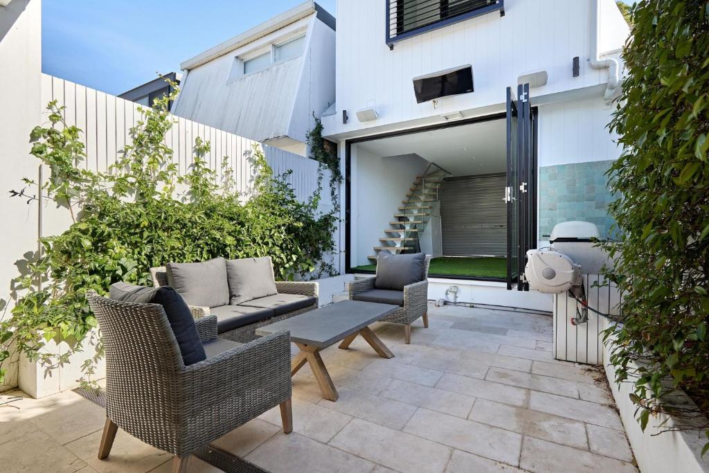 a patio with wicker chairs and a couch at Royal Redfern Isyd in Sydney