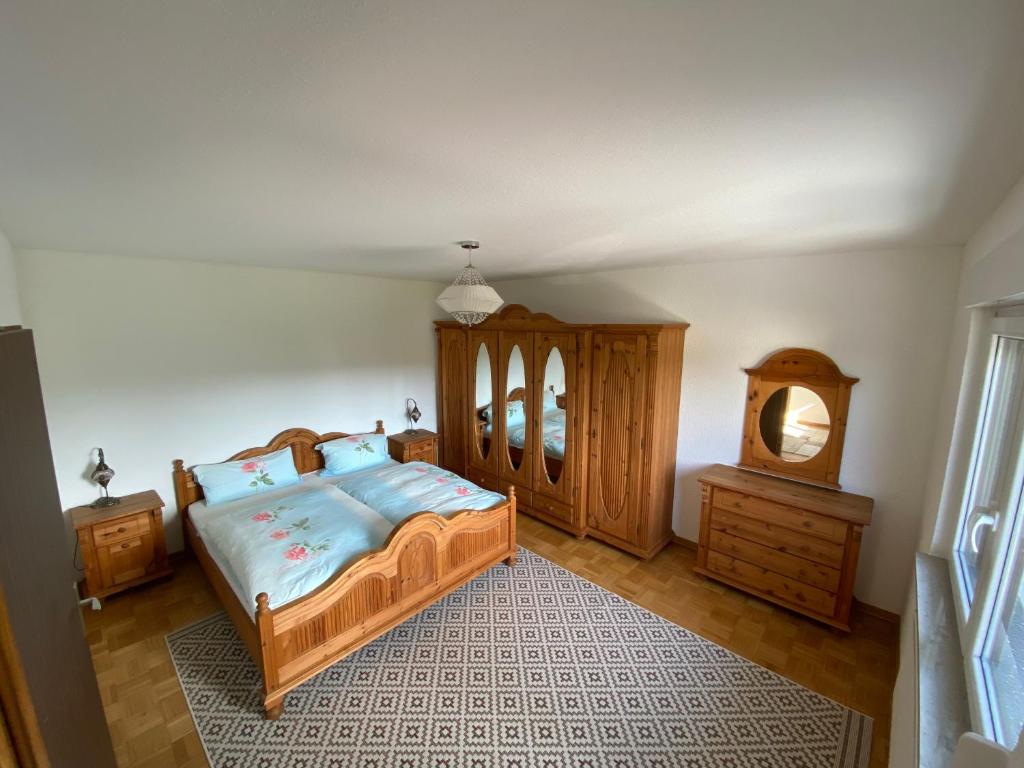 a bedroom with a wooden bed and a wooden dresser at Ferienhaus Hoppstädten 