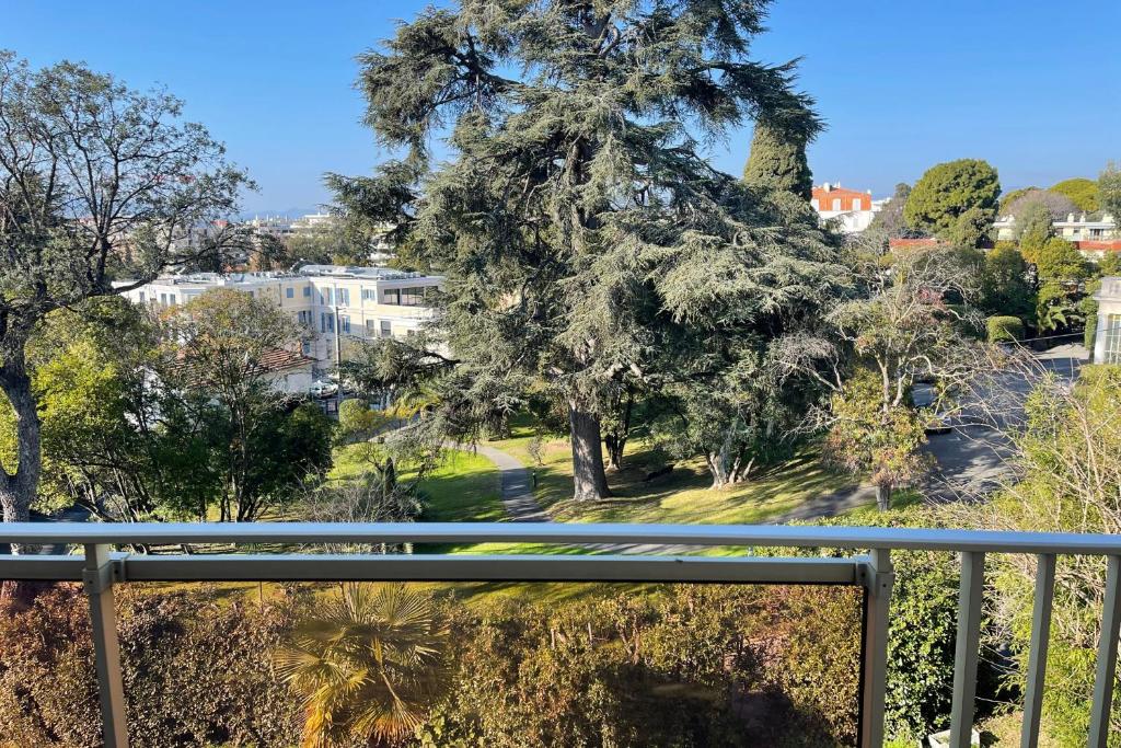 d'un balcon avec vue sur un arbre. dans l'établissement Le Cèdre Magnifique Appartement à Cannes, à Cannes