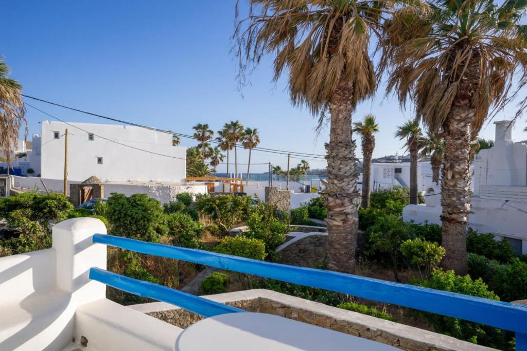 a view from the balcony of a villa with palm trees at Cycladic Ornos Apt Near Mykonos Town in Ornos