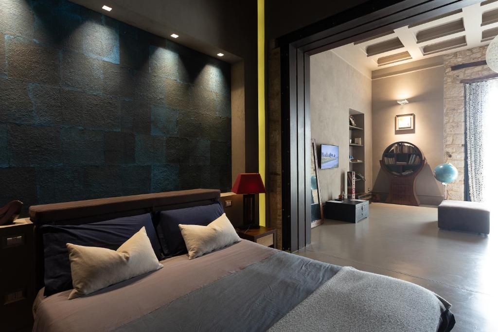 カンポバッソにあるArtStudio6 Dimora Artisticaのレンガの壁、大きなベッド付きのベッドルーム1室