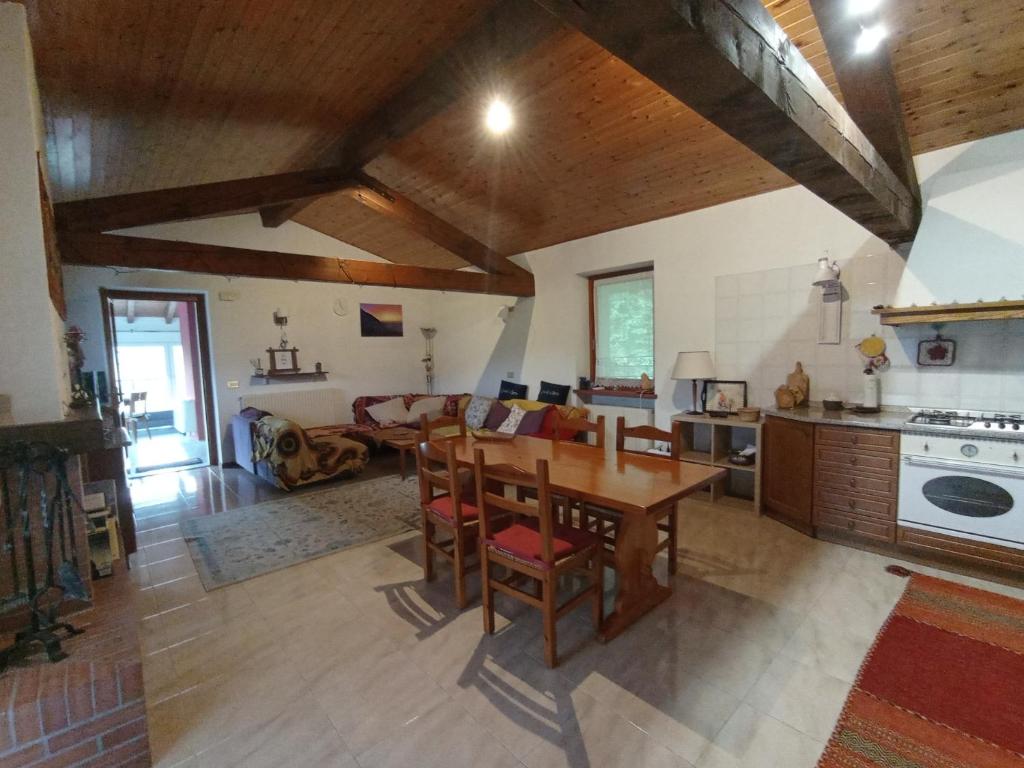 eine Küche und ein Wohnzimmer mit einem Holztisch in der Unterkunft la casa del borgo in Pulfero