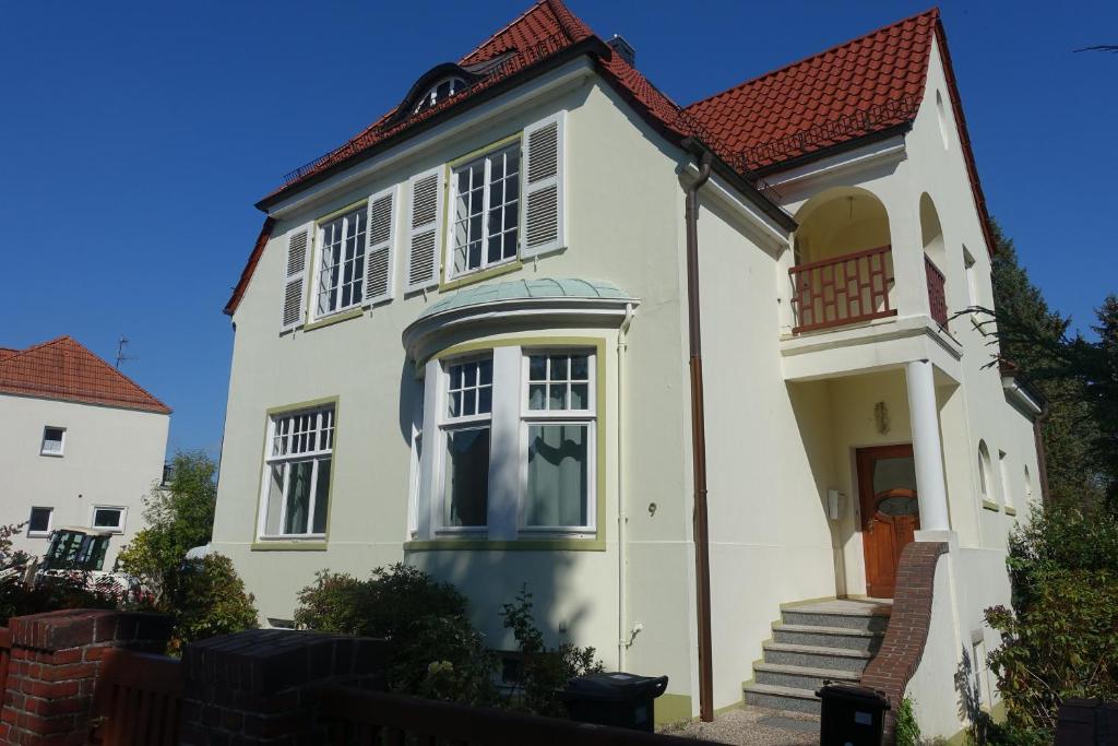 ein weißes Haus mit rotem Dach in der Unterkunft Villa mit 5 Schlafzimmer in Bremen