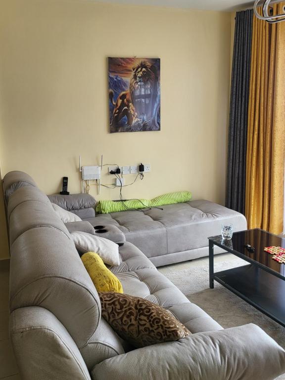 - un salon avec un canapé et une table dans l'établissement G&G Homes Executive Suite, à Nakuru