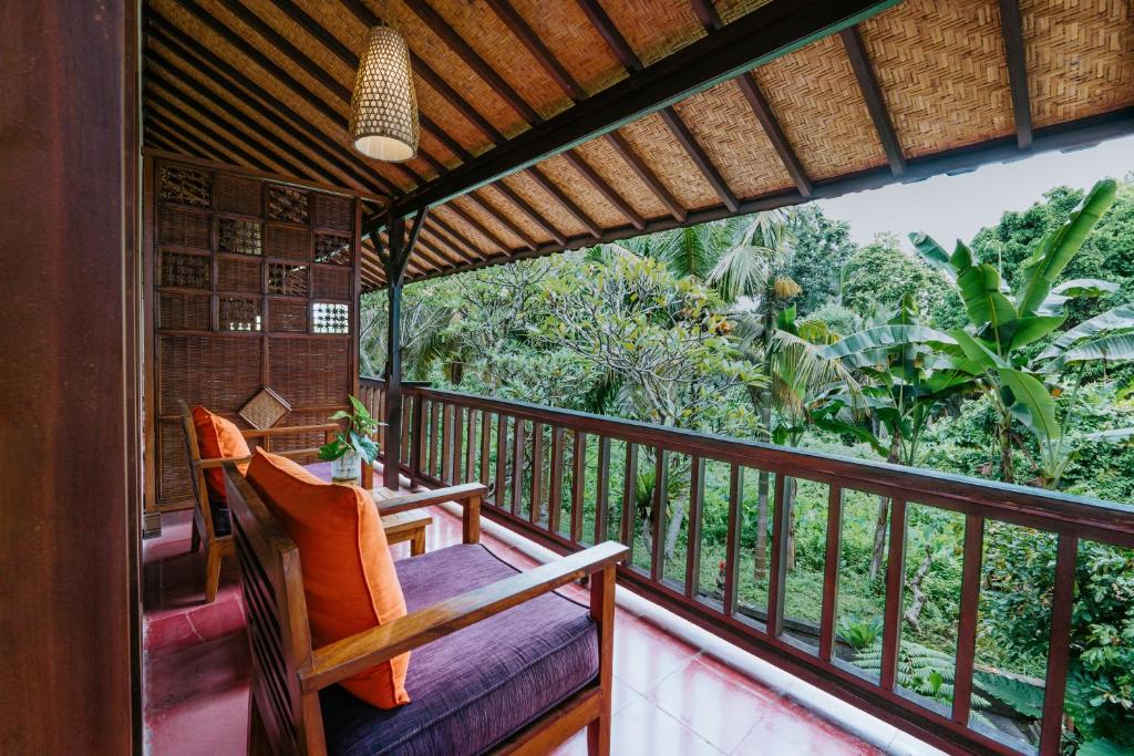 a balcony with a view of the jungle at Jati Home Stay in Ubud