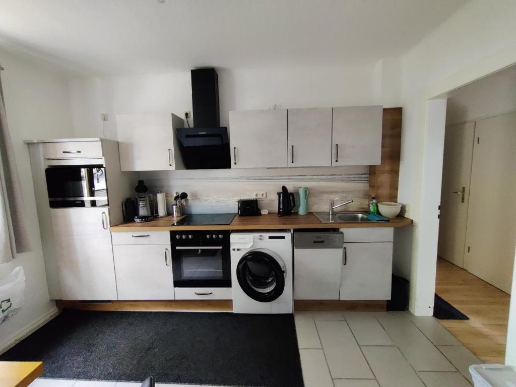 a kitchen with white cabinets and a washer at Ferienwohnung Obere Aue in Niederau
