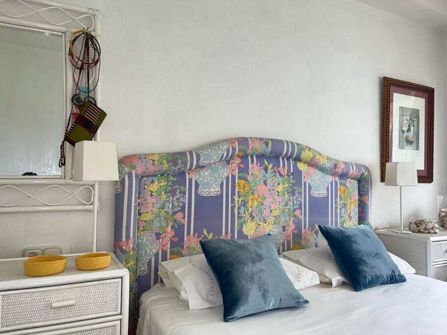 Schlafzimmer mit einem Bett mit farbenfrohem Kopfteil in der Unterkunft Hortensias de jardín in O Grove