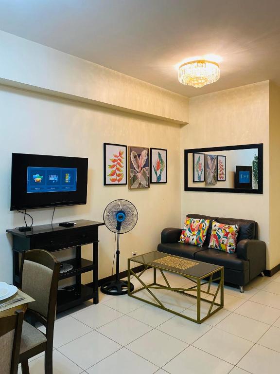 uma sala de estar com um sofá e uma mesa em Hello condo em Manilla
